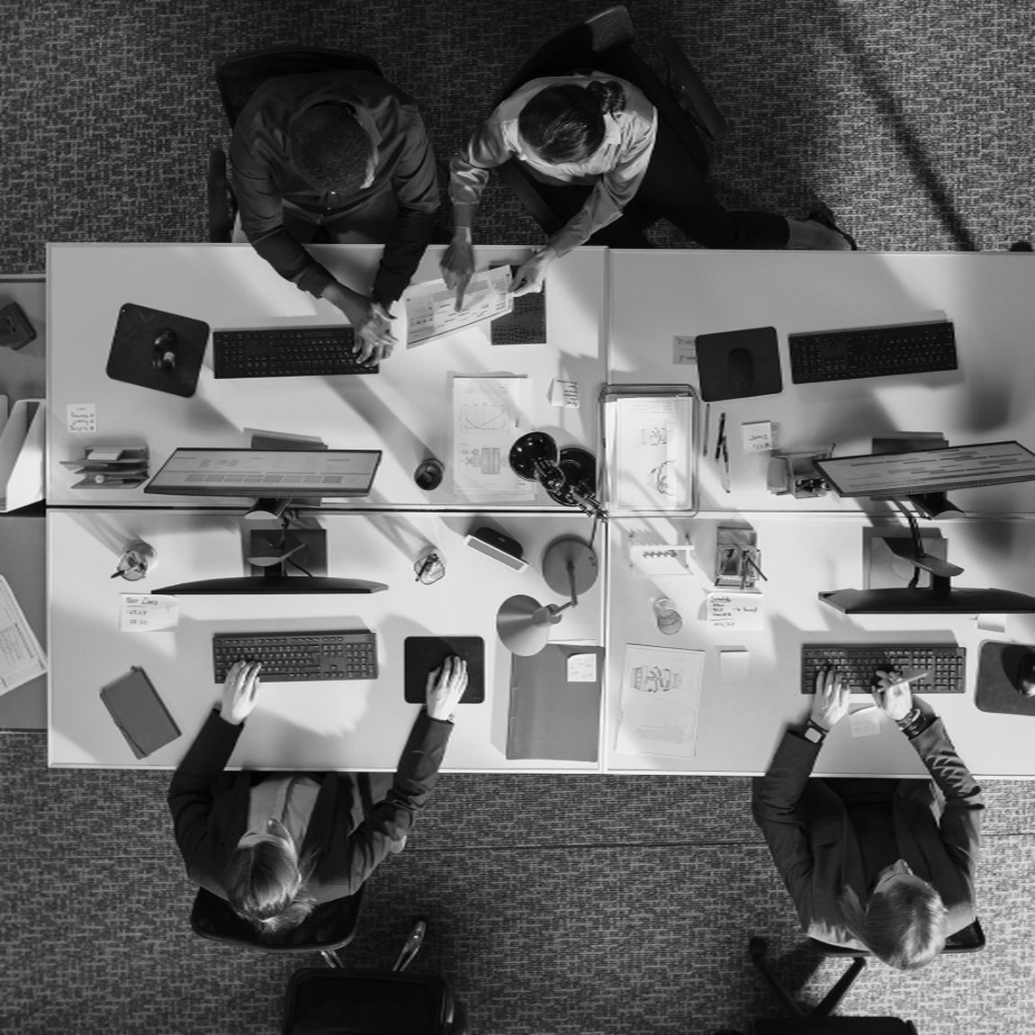 Four people working at desks, seen from above